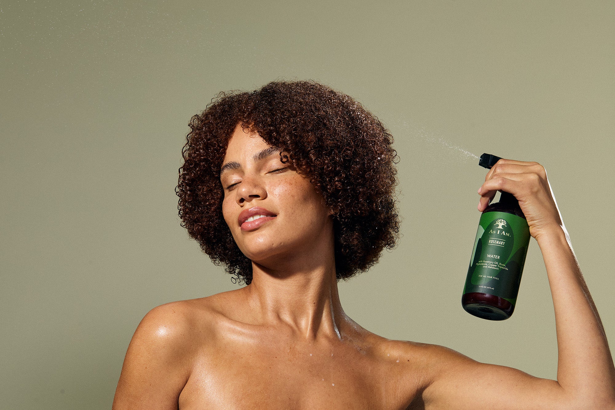Woman holding a green bottle against a beige background