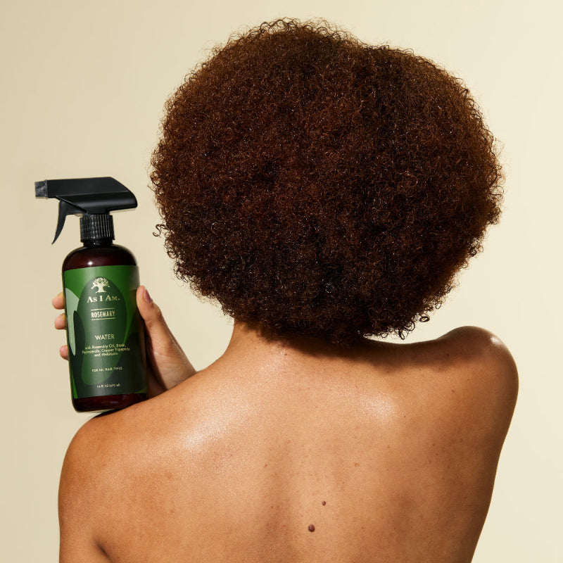 Person holding a green hair care product with a beige background