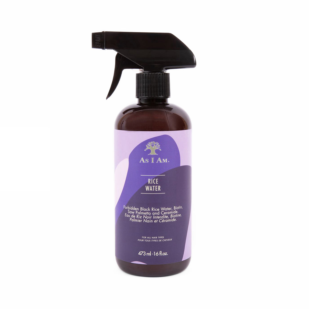 A bottle of As I Am Rice Water hair spray with a spray nozzle, predominantly purple in color with white and green label elements.