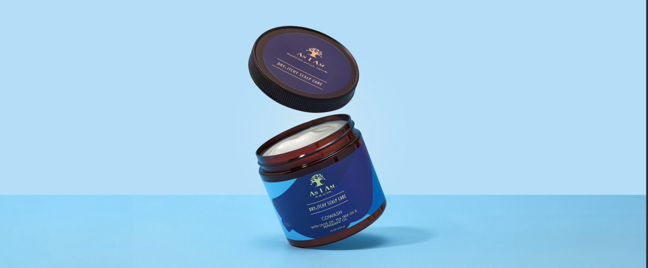 Blue jar of A. J. Ahn hair product on a light blue background