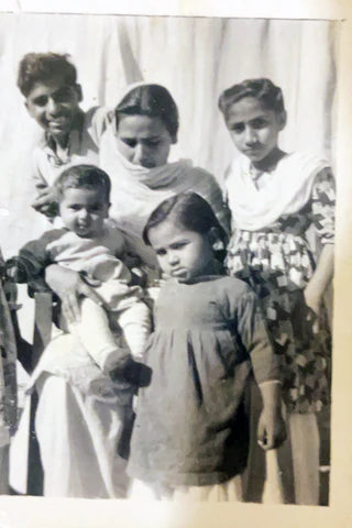 Black and white photo of a family with four children against a plain background