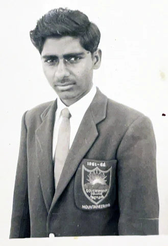 Black and white photo of a person wearing a school uniform with a badge.