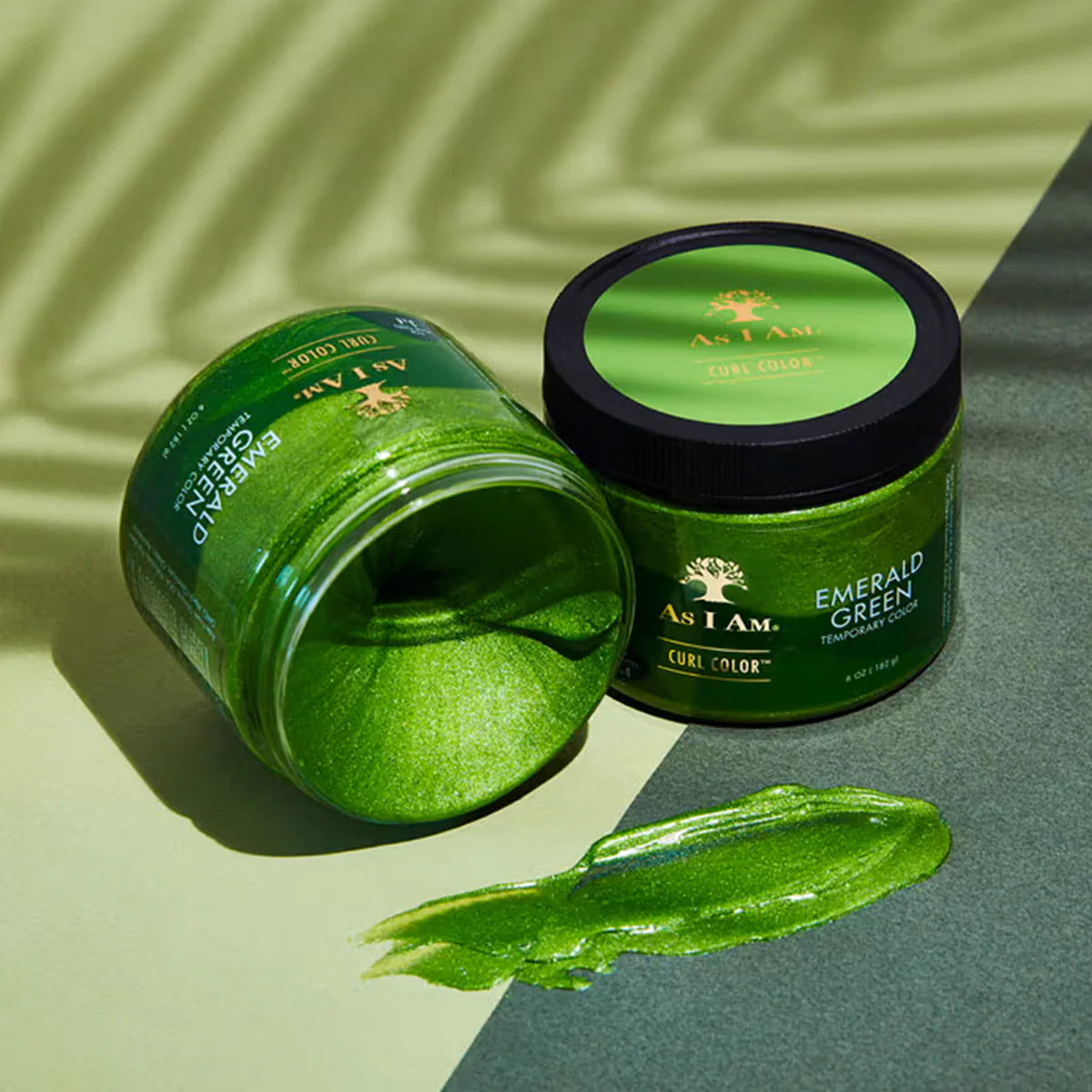 Green hair product jar with open lid on a green and gray background