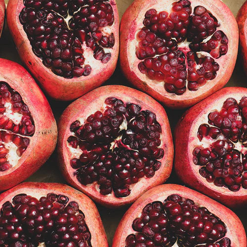 Close-up of halved pomegranates showing juicy red seeds.
