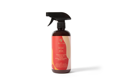 A spray bottle of Jamaican Black Castor Oil Water with a label that includes a picture of coiled hair and text detailing the product's benefits for hair care.